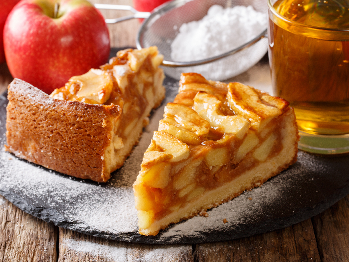 Primer plano tradicional de tarta de manzana en rodajas en la mesa con jugo en una mesa de madera