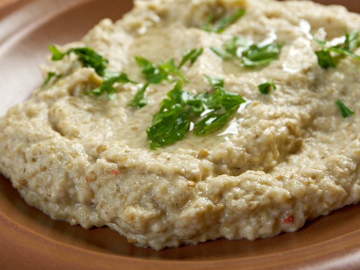 Baba Ganush en un plato de madera oscura con cilantro