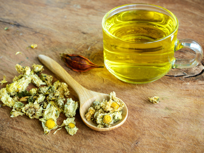 Té de crisantemo chino en vidrio sobre mesa de madera