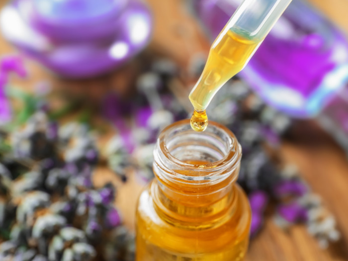 Frasco cuentagotas de aceite esencial de lavanda con fondo borroso