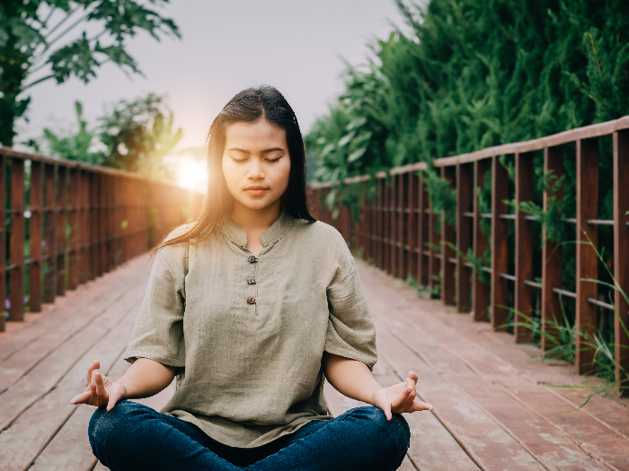 Chica asiática practicando meditación temprano en la mañana