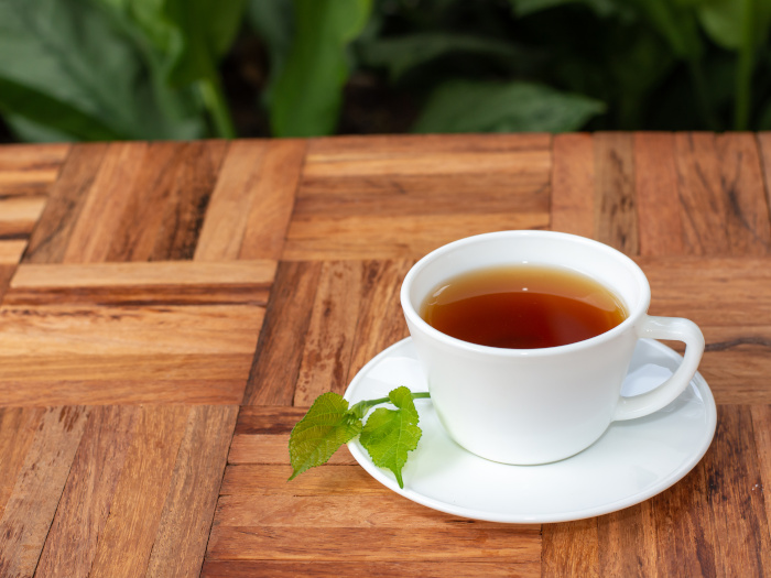 Té de hojas de morera en taza sobre mostrador de madera