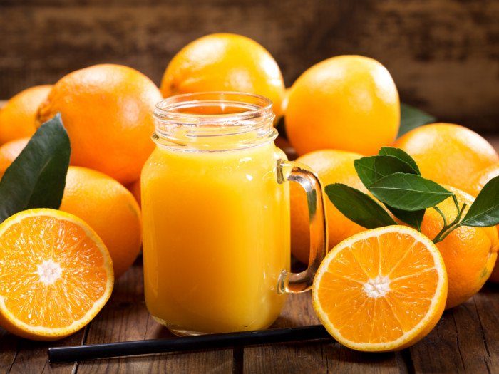 Un frasco lleno de jugo de naranja fresco