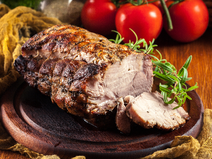 Lomo de cerdo asado con hierbas en una tabla para cortar
