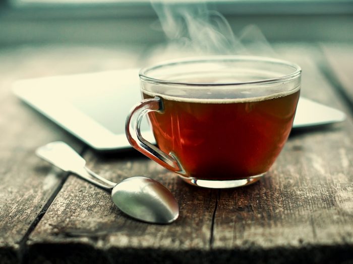 Una taza de té caliente y una cuchara.